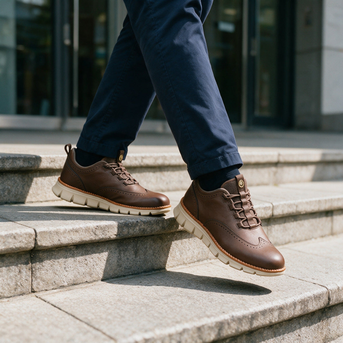 Pemberton wingtip sneaker in Brown, worn on stone steps