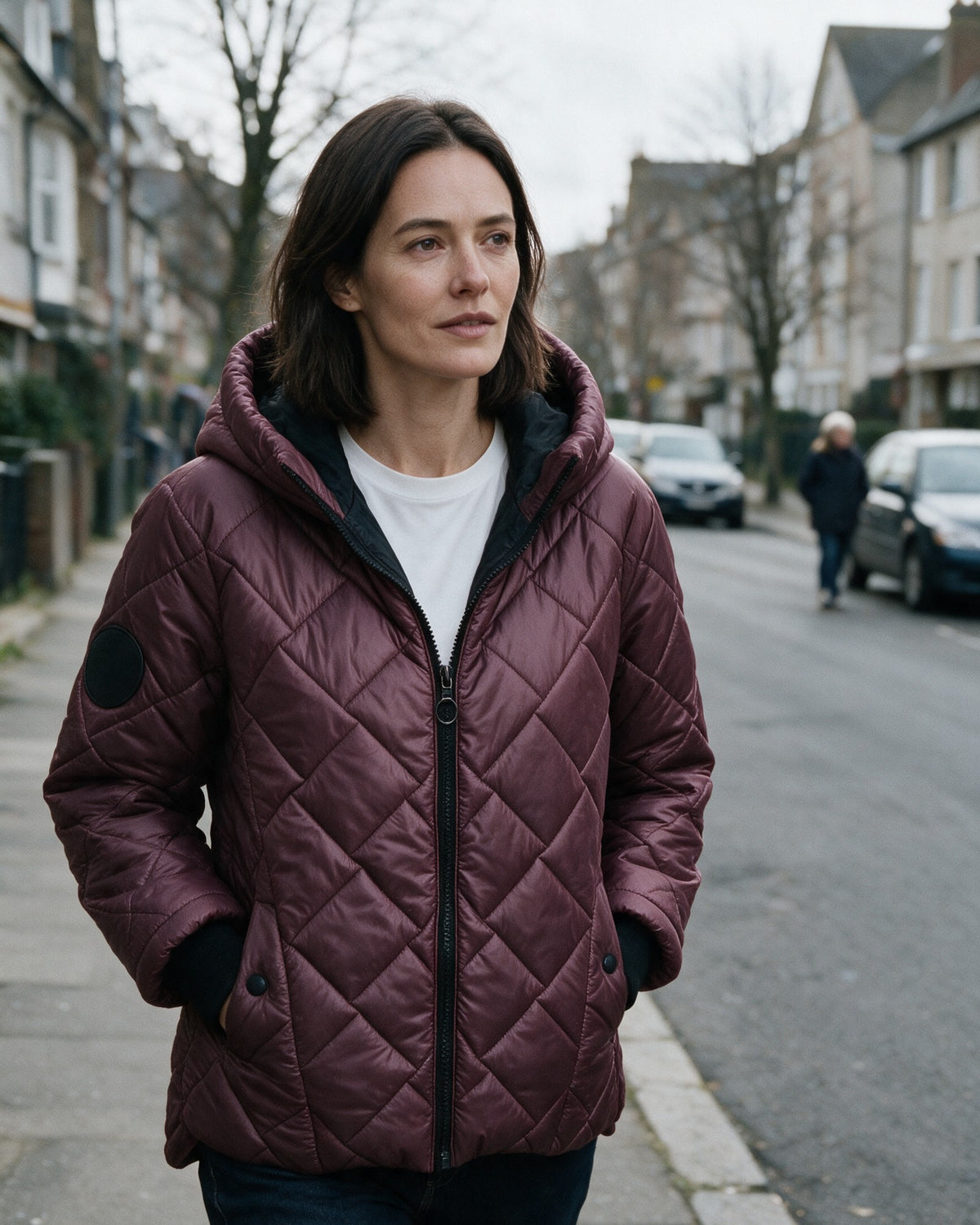 Woman in a burgundy quilted puffer on a cold morning street
